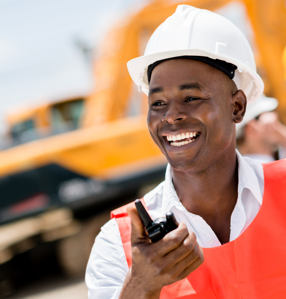 Construction worker with a walkie-talkie looking very happy